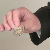 John holding a coin at his fingertips